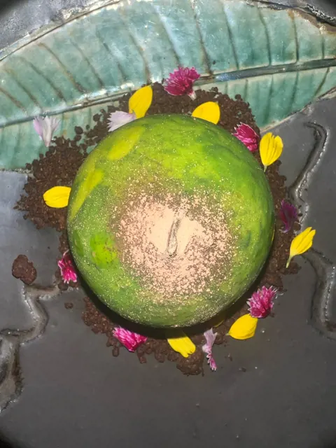 A green dome dessert with flowers