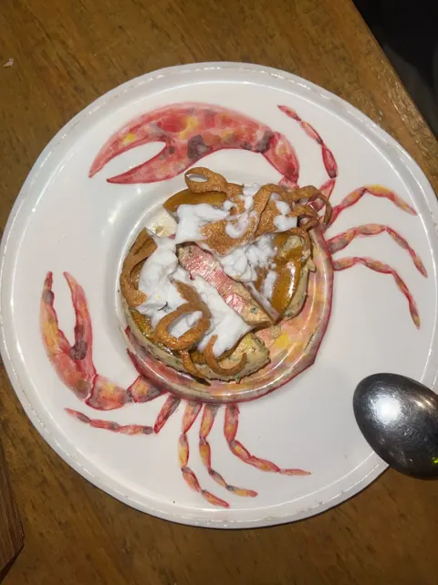 A dish on a plate painted with a crab