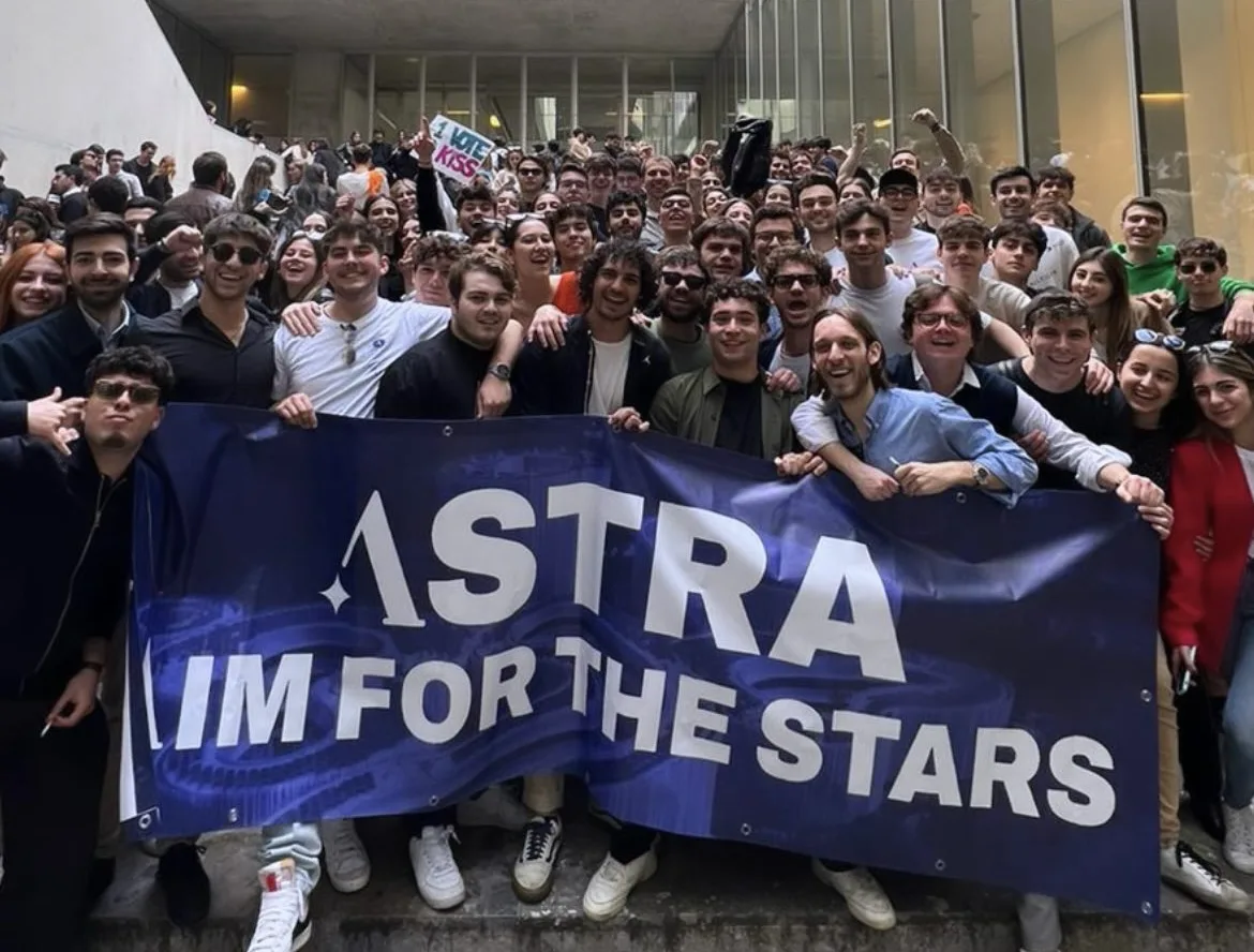 ASTRA members in a Bocconi courtyard holding an “Aim for the stars” banner