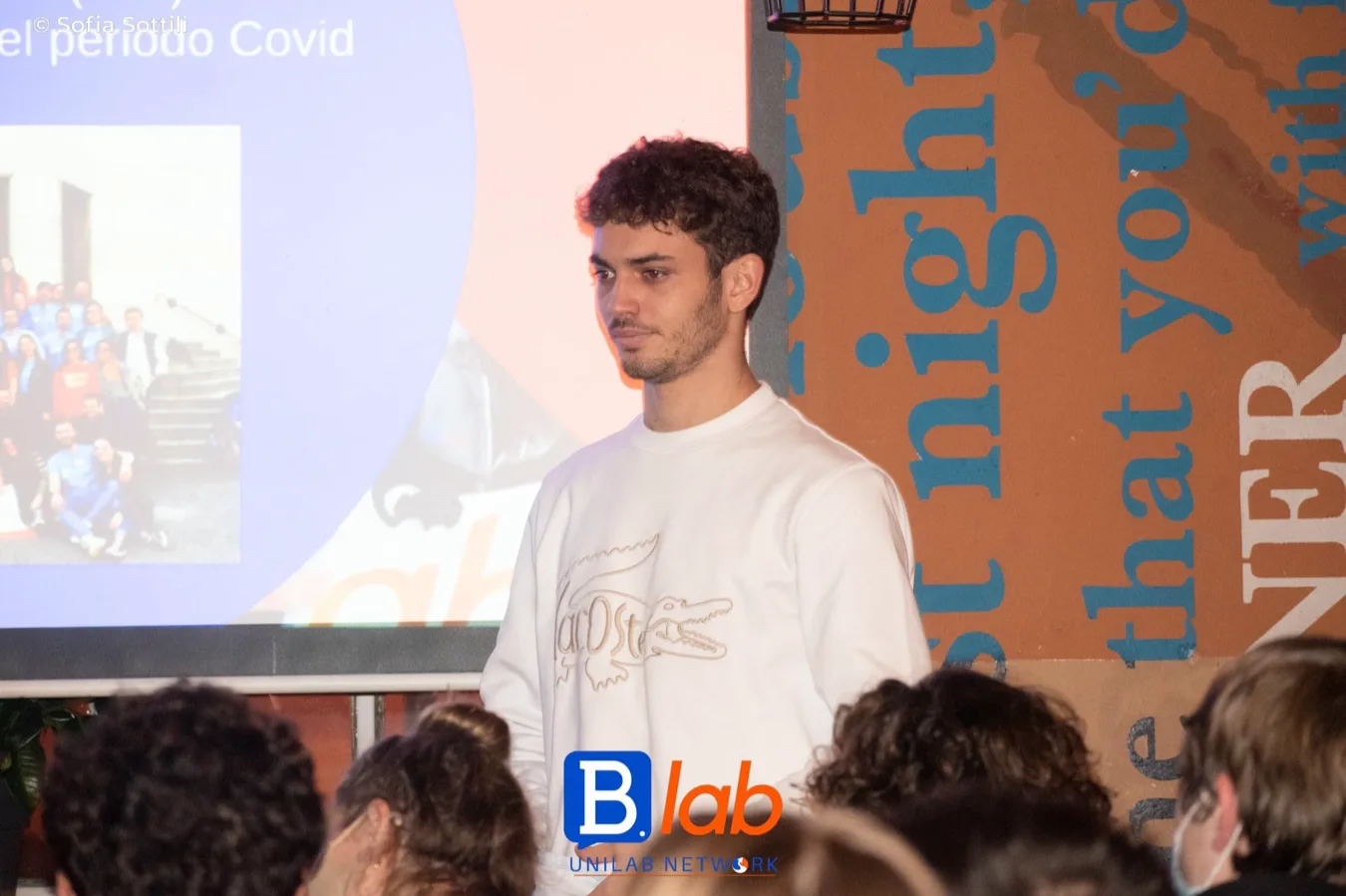 Saverio presenting B.lab in front of a projected slide