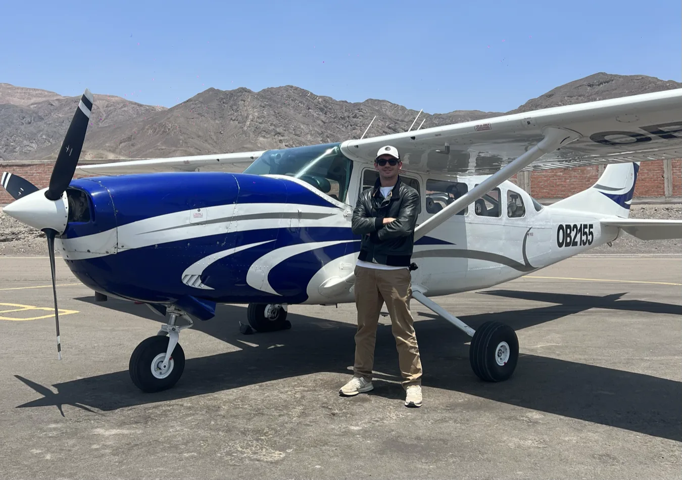 Saverio next to a small propeller plane on a mountain airstrip