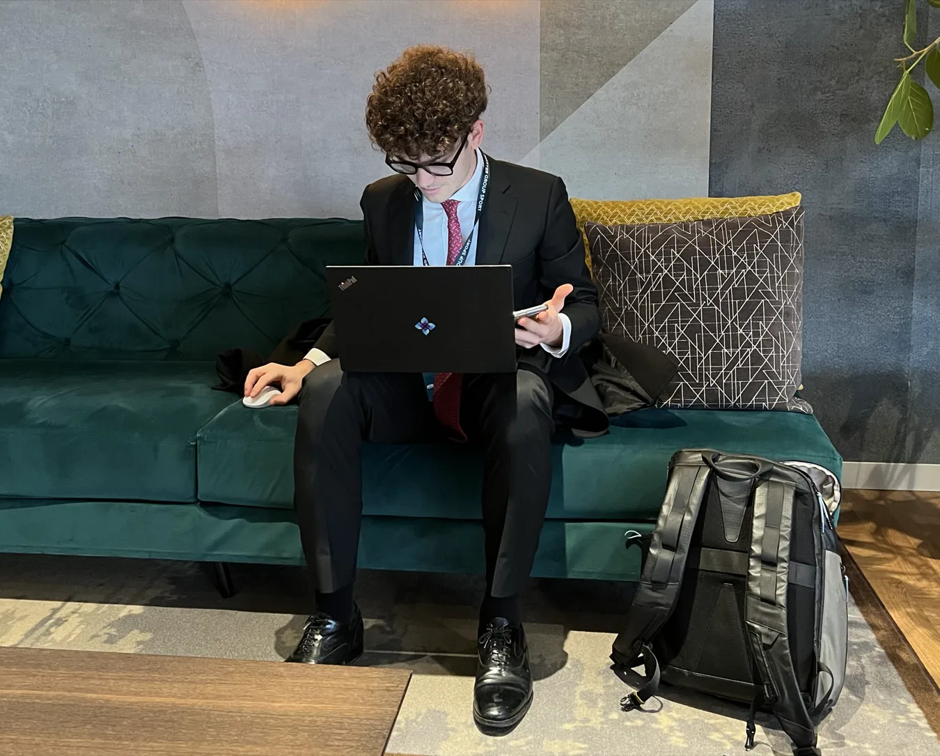 Saverio working on a laptop on a sofa at the office