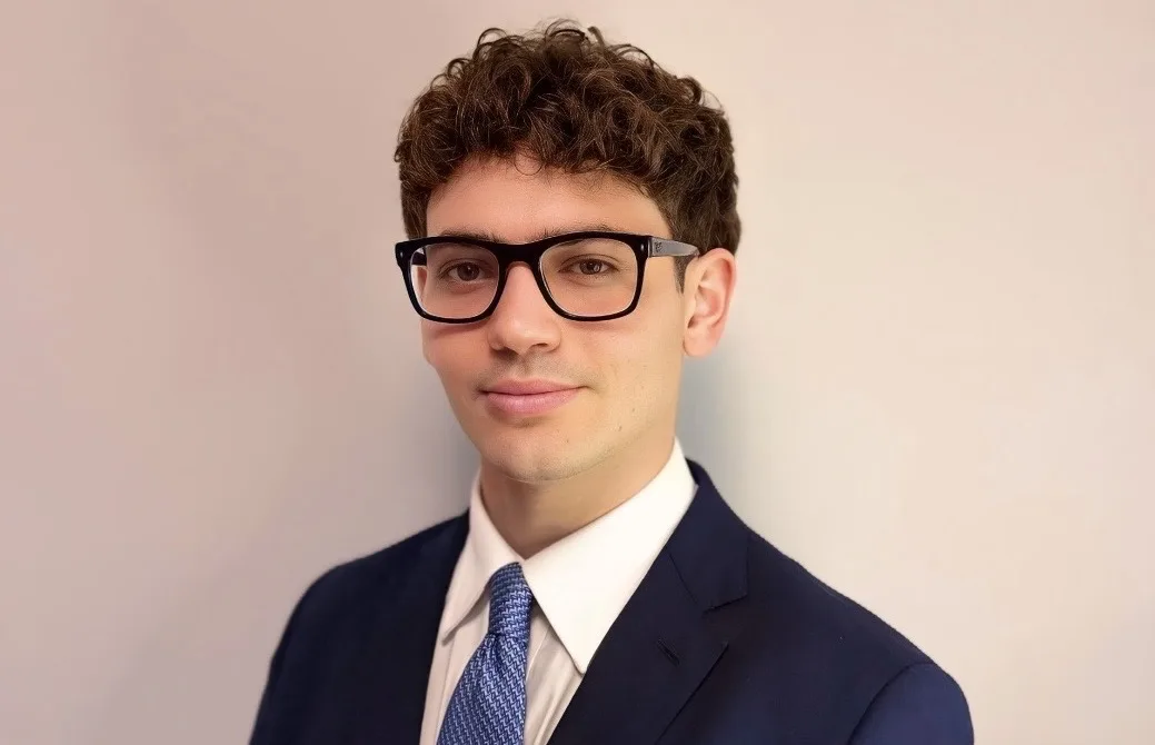 Portrait of Saverio in a navy suit and glasses